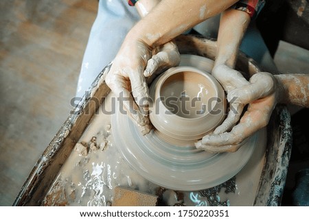 Couple hands making clay pot. Date at the pottery workshop. Closeup picture.