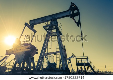 Oil pump rig. Oil and gas production. Oilfield site. Pump Jack are running. Drilling derricks for fossil fuels output and crude oil production. War on oil prices. Global coronavirus COVID 19 crisis.
