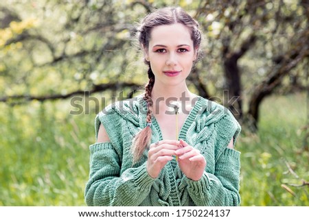 Summer portrait of a woman in nature with a white dandelion
