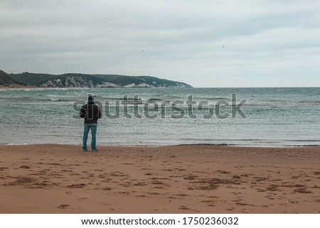 Thoughtful man watching the wavy sea
