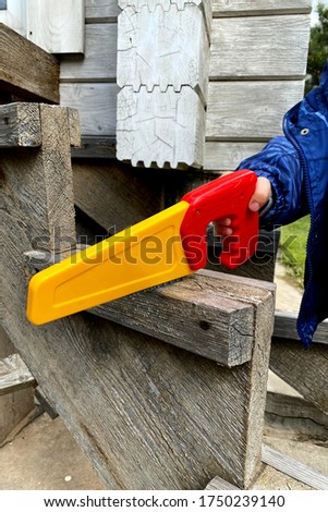 Boy learning to use handsaw Educational games concept.