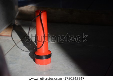 A red flashlight with a blur background