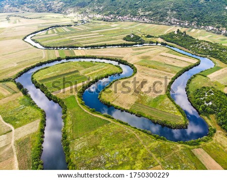Aerial view of river Lika meandering through Donji Kosinj and Lipovo Polje villages in Croatia. Royalty-Free Stock Photo #1750300229