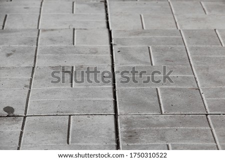 Gray square tiles on the road. Backgrounds.
