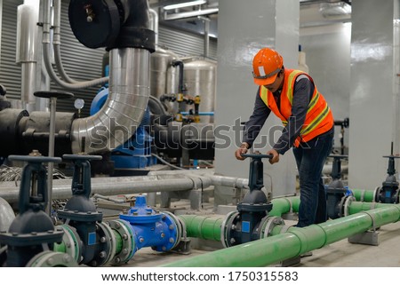 The worker opens the water valve of the chiller. Royalty-Free Stock Photo #1750315583