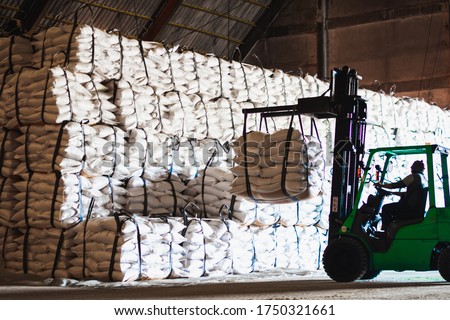 Forklift stacking up sugar bag inside warehouse, sugar warehouse operation. Agriculture product storing and logistics for import and export. Royalty-Free Stock Photo #1750321661
