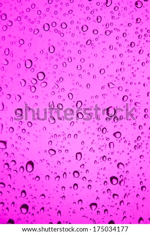Water droplets on pink glass