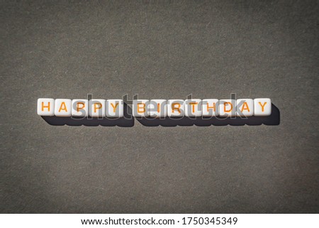 Happy Birthday postcard with orange letters on grey background