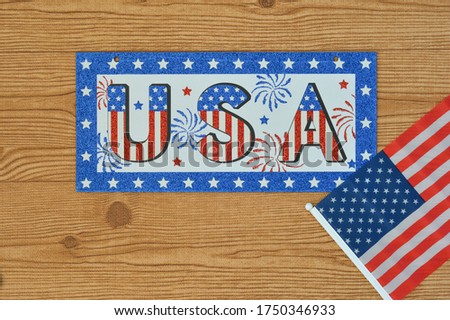 Independence Day July 4th, President's, Memorial, Labor and Veteran's Day, Great America. USA sign in the colors of the flag of the United States on a wooden background with the flag.