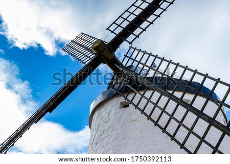 Restored old windmill in Spain blue sky white clouds picture taken from below