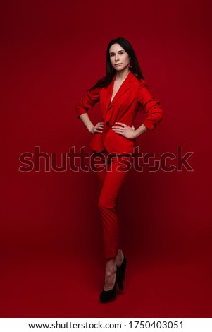 Attractive woman in red suit and black heels.