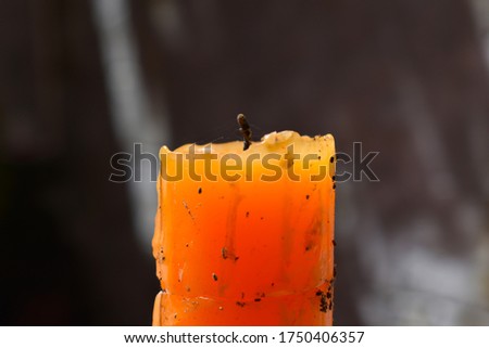 Dusty old orange holiday candle. Spooky candle.