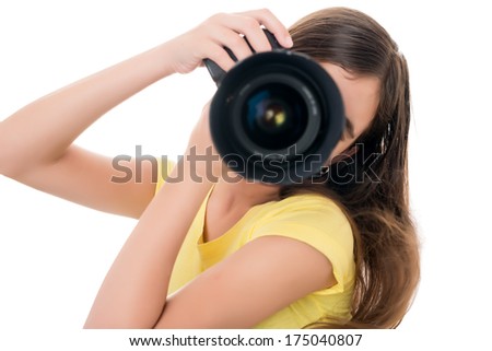 Hispanic girl taking a picture using a professional camera isolated on white