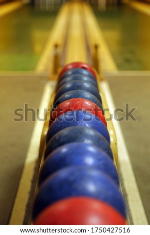 On a nostalgic wooden bowling alley! Focus on the eye-catching red ball - blurred background
