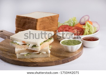 Healthy veg sandwich on wooden board with vegetables and green chutney Royalty-Free Stock Photo #1750442075