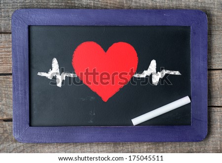 Blackboard on wooden background hand draw with heart 