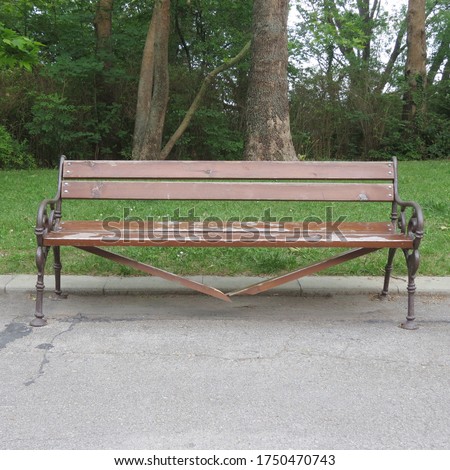 Damaged and broken wooden bench in the city park, vandalism concept. Royalty-Free Stock Photo #1750470743