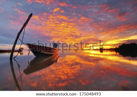 Reflection of Boats with Burning Fire On Cloud During Great Sunrise