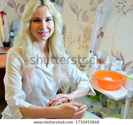Cute girl blonde worker massage while working with patient. Beautician does facial massage. Facial skin care. Beauty and care concept.