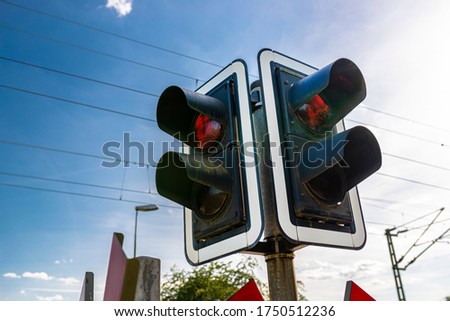 Traffic lights before the railway crossing with a red light to warn of approaching trains.
