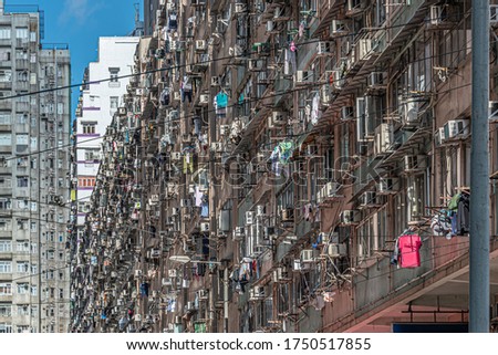 Building residential with clothing hanging from the windows on a sunny day at Hong kong