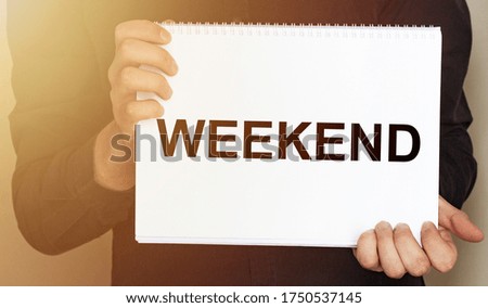 Man holding brochure with WEEKEND text on grey background. Mock up for design