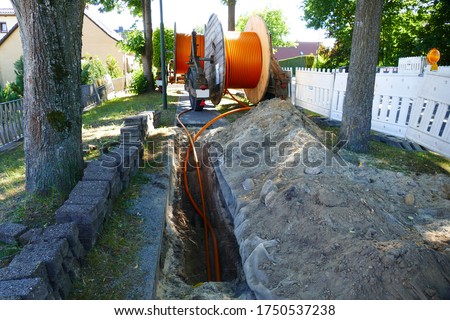 Fiber optic cable laying in the ground, buried cable for faster internet in rural region, near the village Eschede, district Celle, Lower Saxony, Germany Royalty-Free Stock Photo #1750537238
