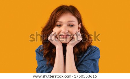 Teen's Portrait. Lovely Millennial Girl Smiling To Camera Posing Touching Face Over Yellow Studio Background. Panorama