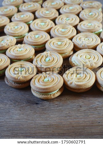 Cookies stuffed cream arranged on wood floor.
