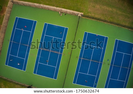 Aerial view of Tennis court shot from above where people are playing Tennis with proper social distancing after reopening post CoVid-19 lock down in suburbs of Atlanta, Georgia