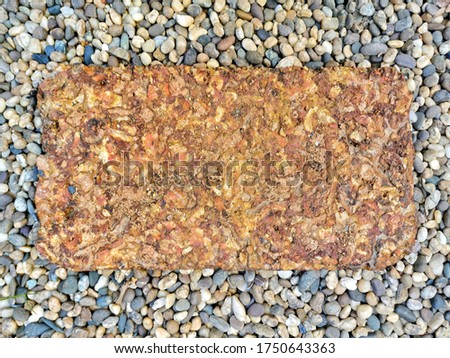 Orange stone slabs and gravel stone decorate the garden walkway. Rough surface of stone.