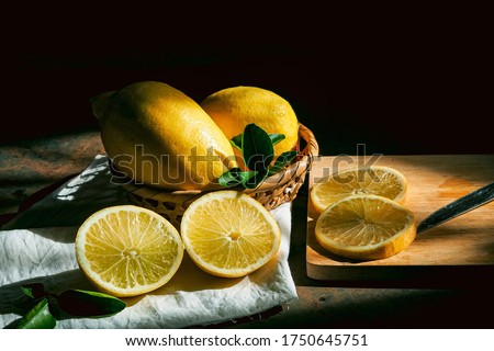 Still life photography in technic of light-painting with lemon and Slicedlemon on the wood desk with light shadow  on the black background