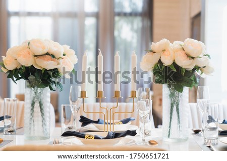 beautiful dining table decoration prop object flower vase candle stand set of dishware with sun light from big white window home interior design concept