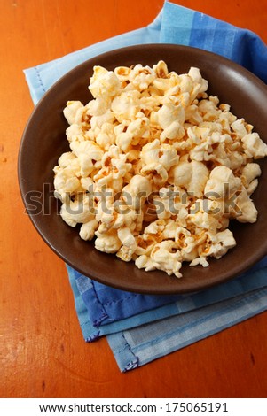 Popcorn in a bowl on wooden background