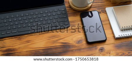 Cropped shot of rustic home office desk with digital tablet, smartphone, schedule books, cup and copy space 