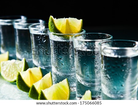tequila and lime on a damp glass table Royalty-Free Stock Photo #175066085