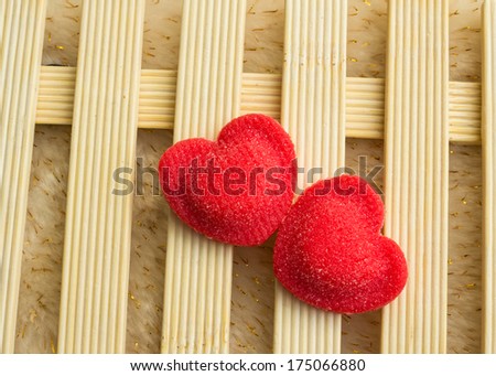 Red candy in sugar in the form of hearts on wood