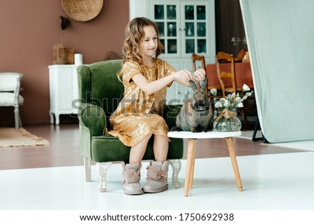 A little girl and her favorite animal is a rabbit. A game for two. Toning.