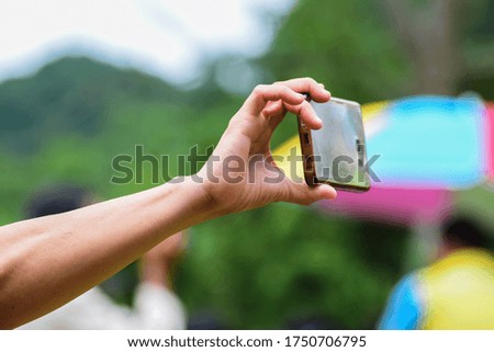 Hand holding phones, taking pictures with a smartphone