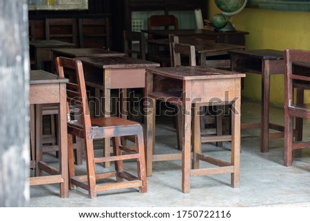 old wooden table for Thai student in urban school. dirty timber desk no student in classroom. Concept : shortage school equipment. school closure caused coronavirus or Coivd-19. Royalty-Free Stock Photo #1750722116