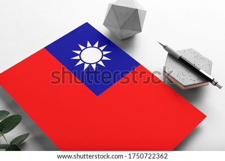 Taiwan flag on minimalist paper background. National invitation letter with stylish pen on stone. Communication concept.