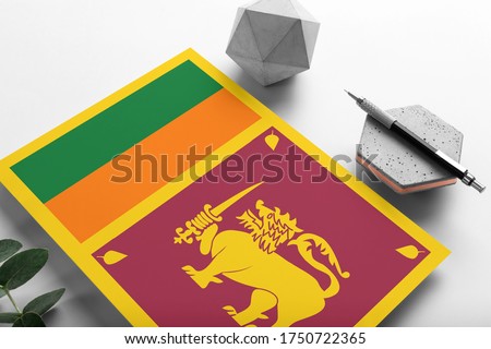 Sri Lanka flag on minimalist paper background. National invitation letter with stylish pen on stone. Communication concept.