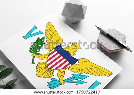 United States Virgin Islands flag on minimalist paper background. National invitation letter with stylish pen on stone. Communication concept.