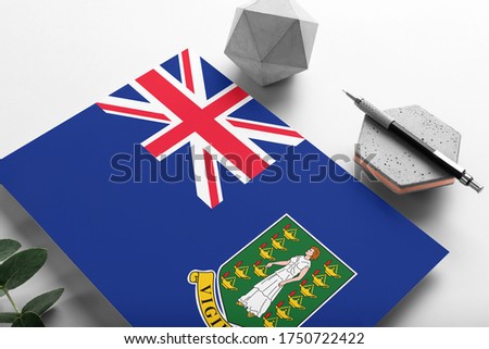 British Virgin Islands flag on minimalist paper background. National invitation letter with stylish pen on stone. Communication concept.