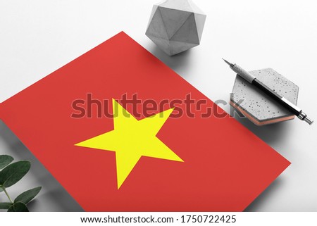 Vietnam flag on minimalist paper background. National invitation letter with stylish pen on stone. Communication concept.