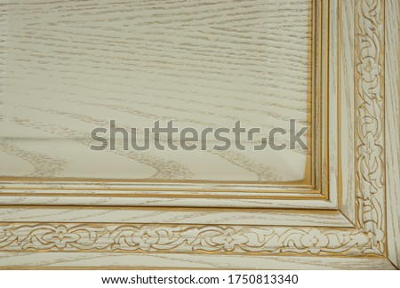 White vintage wooden corner with a frame and an ornament from solid wood with a border and a golden patina in the texture, closeup - ideas for repair, furniture design and just a photo of beautiful wo