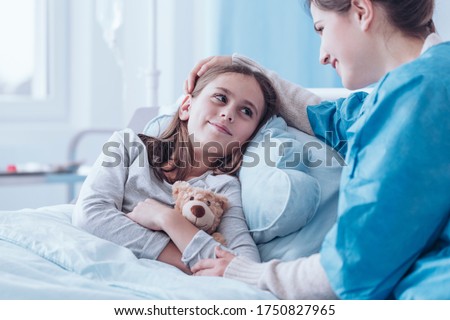 Smiling mother visiting sick daughter in hospital Royalty-Free Stock Photo #1750827965