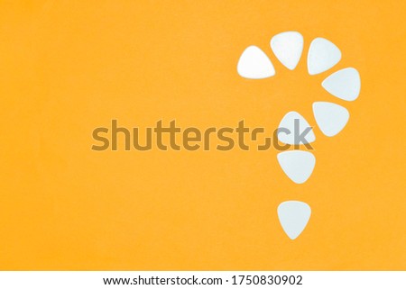 Bright background with an empty place for text and a question mark composed of guitar picks