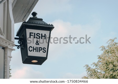 Low angle view of Fish and Chip sign outside a restaurant in London, UK, against the sky, copy space.