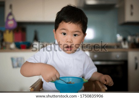 Asian boy sitting and eating breakfast